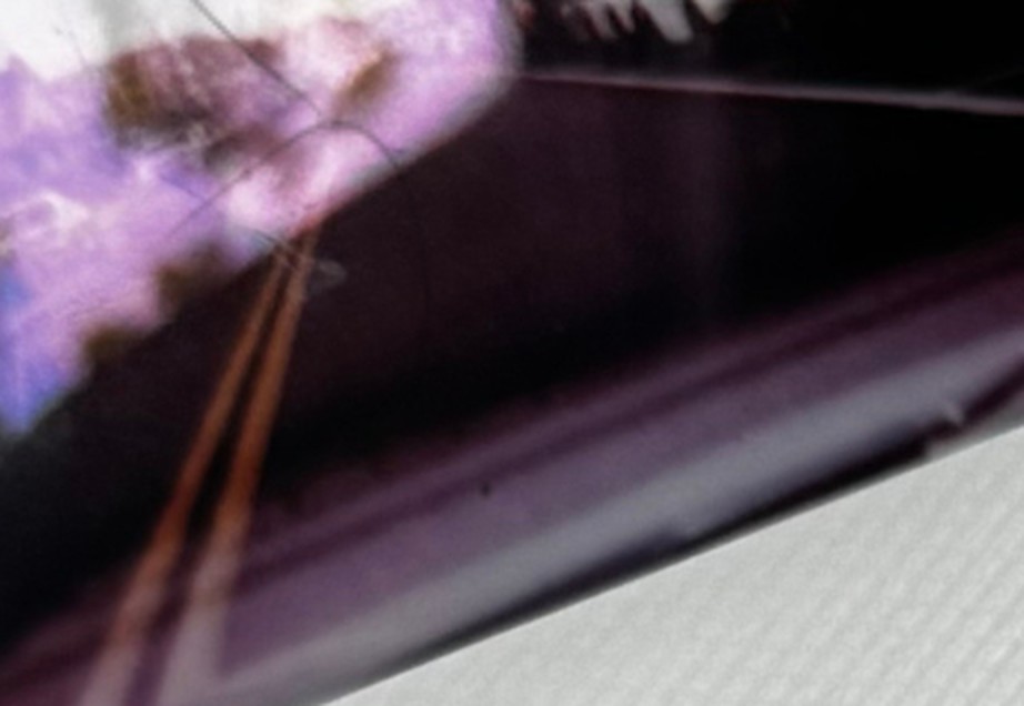 Blurred night photograph of a road through a car window, lit by violet light